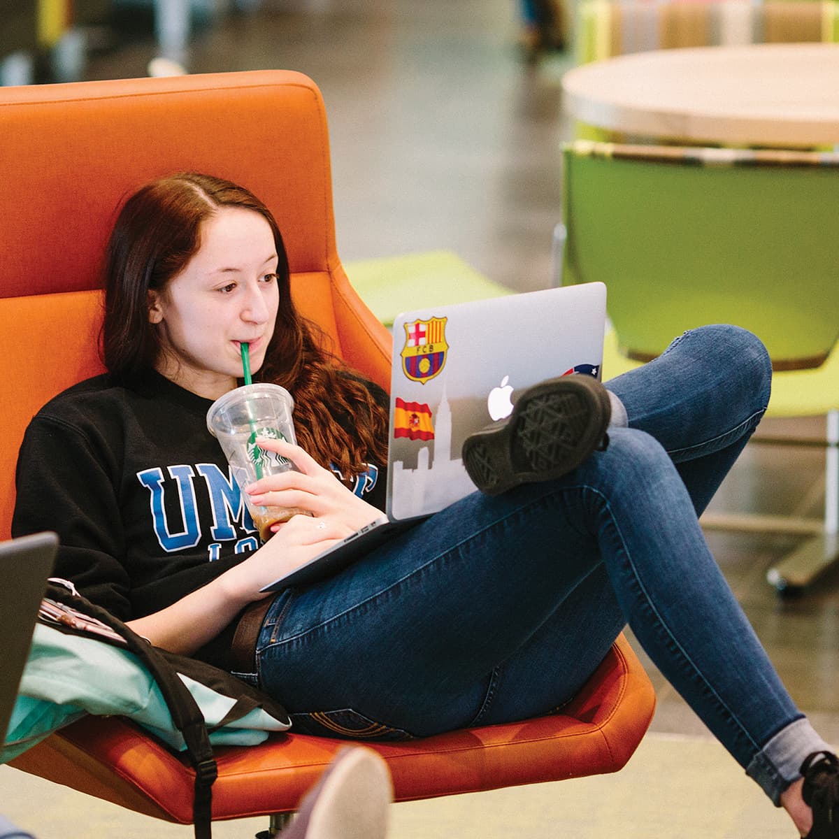 Student relaxing in an orange chair